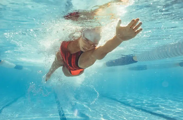 Professional athlete swimming freestyle during training, representing endurance, recovery, and performance-focused lifestyle in 2026